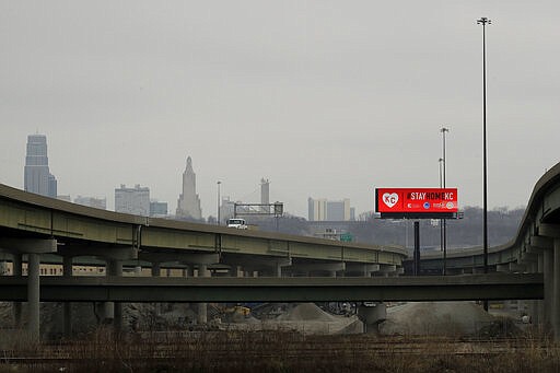 A sign urging citizens to stay home stands along freeways leading to downtown Kansas City, Mo. Tuesday, March 24, 2020 on the first day of a stay-at-home order. Kansas City and surrounding counties instituted a 30-day mandatory stay-at-home order in an effort to stem the spread of the coronavirus. (AP Photo/Charlie Riedel)