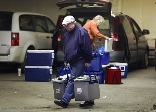 Andy O'Brien prepares to make food deliveries for Meals on Wheels of NEPA in Scranton, Pa., on Wednesday, March 25, 2020. Meals on Wheels of NEPA has increased the amount of food and decreased the about of times they bring the food to recipients to protect their workers and recipients of the free meals from COVID-19. (Jake Danna Stevens/The Times-Tribune via AP)