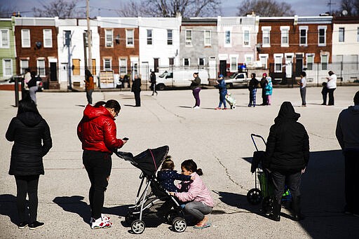 People, standing several feet of distance from each other as an extra precaution out of concern about the spread of the coronavirus, wait in line to receive donated food and educational materials at the John H. Webster Elementary School in Philadelphia, Thursday, March 26, 2020. Gov. Tom Wolf&#146;s administration reported more coronavirus-related deaths in Pennsylvania on Wednesday. Residents are ordered to stay home, with few exceptions.&#160;(AP Photo/Matt Rourke)