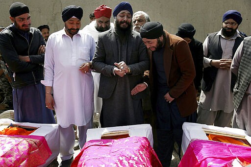 Afghan Sikh men mourn their beloved ones during a funeral procession for those who were killed on Wednesday by a lone Islamic State gunman, rampaged through a Sikh house of worship, in Kabul, Afghanistan, Thursday, March 26, 2020. An explosive device disrupted Thursday's funeral service for 25 members of Afghanistan's Sikh minority community, killed in an attack by the Islamic State group on their house of worship in the heart of the capital. (AP Photo/Tamana Sarwary)