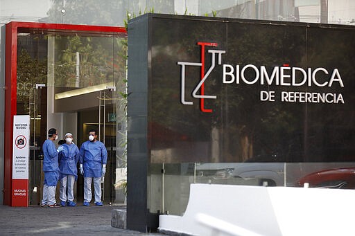 Medical workers wait to guide people arriving to get tested for COVID-19 at private laboratory Biomedica de Referencia, in the Lomas Virreyes neighborhood in Mexico City, Thursday, March 26, 2020. The new coronavirus causes mild or moderate symptoms for most people, but for some, especially older adults and people with existing health problems, it can cause more severe illness or death. (AP Photo/Rebecca Blackwell)