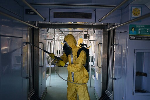 A soldier disinfects a wagon parked at the central train station in Rio de Janeiro, Brazil, where trains connect cities within the state, as a measure to stop the spread the new coronavirus, Thursday, March 26, 2020. COVID-19 causes mild or moderate symptoms for most people, but for some, especially older adults and people with existing health problems, it can cause more severe illness or death. (AP Photo/Leo Correa)