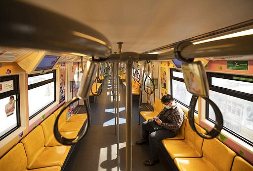 A commuter wears face mask to protect himself from new coronavirus at a skytrain in Bangkok, Thailand, Thursday, March 26, 2020. Department of Rail Transport issued regulation requiring commuters to wear face marks while inside station and riding on train. First day of month long state of emergency was enforced in Thailand to allow its government to impose stricter measures to control the coronavirus that has infected hundreds of people in the Southeast Asian country. (AP Photo/Sakchai Lalit)