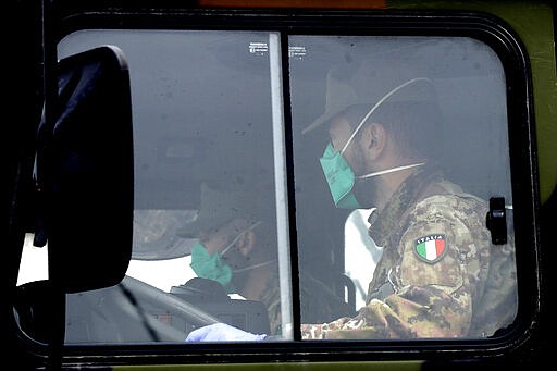 Military trucks moving coffins of deceased people leave the cemetery of Bergamo, one of the areas worst hit by the coronavirus infection, on their way to a crematory in some other location as the local crematory exceeded its maximum capacity, Thursday, March 26, 2020. The new coronavirus causes mild or moderate symptoms for most people, but for some, especially older adults and people with existing health problems, it can cause more severe illness or death. (AP Photo/Luca Bruno)