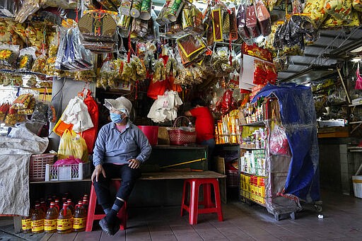 A vendor waits for customers at a market during the movement control order due to the outbreak of the new coronavirus in Kajang, outskirts of Kuala Lumpur, Malaysia, Thursday, March 26, 2020. For most people the new coronavirus causes only mild or moderate symptoms, but for some it can cause more severe illness. (AP Photo/Vincent Thian)