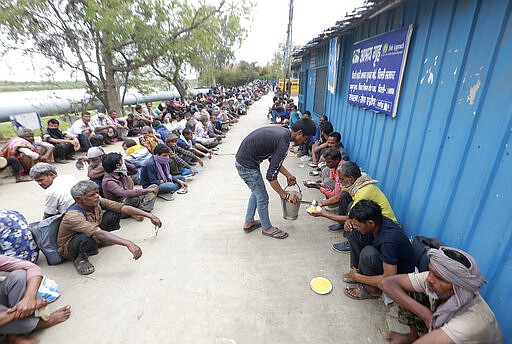 Homeless and impoverished Indians receive food at a government shelter in New Delhi, India, Thursday, March 26, 2020. Some of India's legions of poor and people suddenly thrown out of work by a nationwide stay-at-home order began receiving aid distribution Thursday, as both the public and private sector work to blunt the impact of efforts to curb the coronavirus pandemic. (AP Photo)