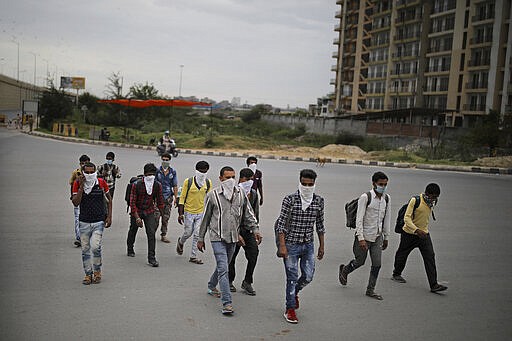 A group of Indian daily wage laborers walk along an expressway hoping to reach their homes, hundreds of miles away, as the city comes under lockdown in Ghaziabad, on the outskirts of New Delhi, India, Thursday, March 26, 2020. Some of India's legions of poor and people suddenly thrown out of work by a nationwide stay-at-home order began receiving aid distribution Thursday, as both the public and private sector work to blunt the impact of efforts to curb the coronavirus pandemic. Untold numbers of them are now out of work and many families have been left struggling to eat. (AP Photo/Altaf Qadri)