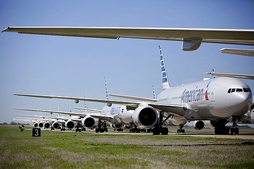 American Airlines 777's airplanes are parked at Tulsa International Airport Wednesday, March 25, 2020. American Airlines has 44 out of service airplanes parked at the airport due to a reduced flight schedule because of the COVID-19 coronavirus pandemic. (Mike Simons/Tulsa World via AP)