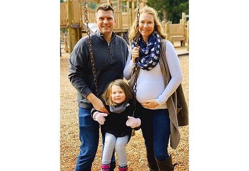 In this photo provided by Kelly McCarty, McCarty is shown with her husband, Bill, and their daughter Langley. Kelly McCarty is one of several dozen expectant Moms who had planned to give birth in the birthing center of Swedish Medical Center's facility in Edmonds, Wash., north of Seattle, but instead will go to an affiliated hospital in Everett, Wash., because the Edmonds birthing center is being repurposed to treat victims of the new coronavirus. (Bob Smith/Courtesy of Kelly McCarty via AP)