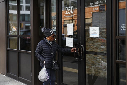 Visitors are unable to gain access to the Department of Labor due to closures over coronavirus concerns, Wednesday, March 18, 2020, in New York. Applications for jobless benefits are surging in some states as coronavirus concerns shake the U.S. economy. The sharp increase comes as governments have ordered millions of workers, students and shoppers to stay home as a precaution against spreading the virus that causes the COVID-19 disease. (AP Photo/John Minchillo)