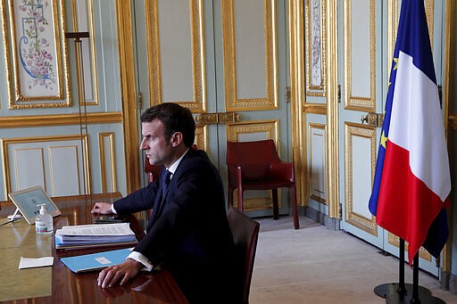 French President Emmanuel Macron attends a videoconference with G20 leaders to discuss the coronavirus disease outbreak, at the Elysee Palace in Paris, Thursday, March 26, 2020. European Union leaders are convening for their third summit in three weeks as they battle to contain the spread of the coronavirus and its devastating health impact while managing the havoc the disease is wreaking on their 27 economies. The new coronavirus causes mild or moderate symptoms for most people, but for some, especially older adults and people with existing health problems, it can cause more severe illness or death. (Benoit Tessier/Pool via AP)