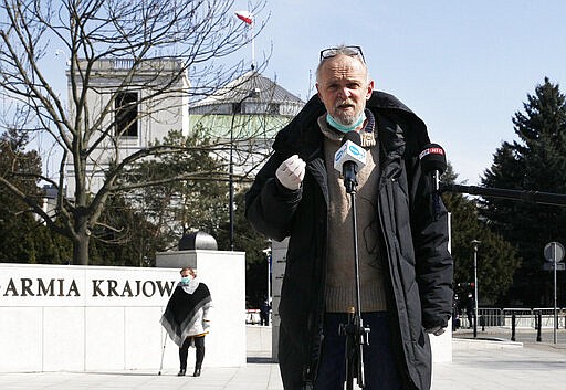 Leader of an opposition group &quot;Citizens of Poland,&quot; Pawel Kacprzak speaks to media ahead of a special session to changes the voting regulations to allow lawmakers remote online participation as a protective measure against the spread of the coronavirus in Warsaw, Poland, Thursday, March 26, 2020. The new coronavirus causes mild or moderate symptoms for most people, but for some, especially older adults and people with existing health problems, it can cause more severe illness or death.(AP Photo/Czarek Sokolowski)