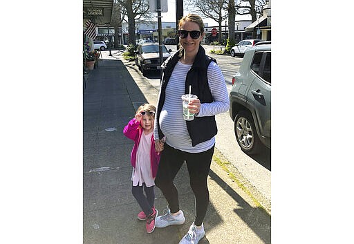 In this photo provided by Kelly McCarty, McCarty is shown with her daughter Langley. McCarty is one of several dozen expectant Moms who had planned to give birth in the birthing center of Swedish Medical Center's facility in Edmonds, Wash., north of Seattle, but instead will go to an affiliated hospital in Everett, Wash., because the Edmonds birthing center is being repurposed to treat victims of the new coronavirus. (Bill McCarty/Courtesy of Kelly McCarty via AP)