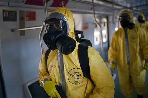 Soldiers disinfect wagons parked at the central train station in Rio de Janeiro, Brazil, where trains connect cities within the state, as a measure to stop the spread the new coronavirus, Thursday, March 26, 2020. COVID-19 causes mild or moderate symptoms for most people, but for some, especially older adults and people with existing health problems, it can cause more severe illness or death. (AP Photo/Leo Correa)