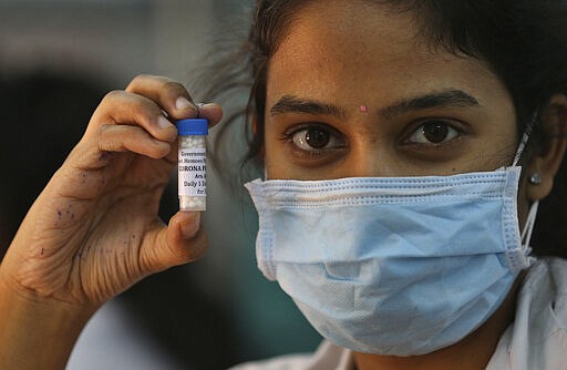 FILE - In this Thursday, March 5, 2020, file photo, an Indian doctor displays homeopathy medicine recommended by a group of experts under India's AYUSH ministry, that claims to prevent COVID-19, at a government hospital in Hyderabad, India. As South Asian nations, including India, brace for the likely spread of the virus, they are facing another battle: reams of misinformation, misleading rumors and false claims. In India, a major challenge comes from advisories released by a parallel health ministry set up by the Modi government that promotes alternative therapies such as yoga and traditional Ayurveda medicine. The advisories by AYUSH recommend herbs and homeopathy as cures and prescribe virus prevention methods. These advisories have drawn widespread criticism. (AP Photo/Mahesh Kumar A., File)