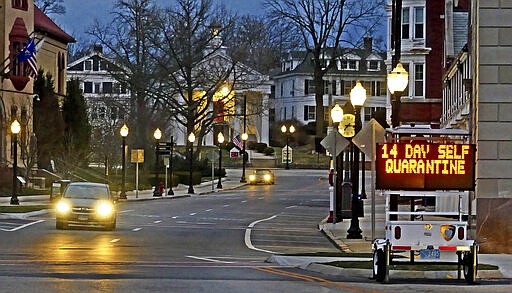 In this Thursday, March 26, 2020 photo, an electronic sign in downtown Westerly, R.I., informs motorists coming of a quarantine policy announced by Gov. Raimondo. Travelers from New York will be required to self-quarantine for 14 days upon arriving in the state. (Harold Hanka/The Sun via AP)