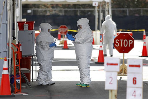 Medical University of South Carolina healthcare providers dress in protective suiting, Friday, March 13, 2020, in Charleston, S.C., as they get ready to open the hospital's drive-thru tent for patients who are being tested for the COVID-19 coronavirus at the Citadel Mall parking lot. The vast majority of people recover from the new coronavirus. According to the World Health Organization, most people recover in about two to six weeks, depending on the severity of the illness. (AP Photo/Mic Smith)