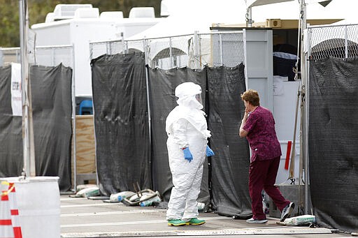 Medical University of South Carolina healthcare providers dress in protective suiting as they get ready to see patients by the hospital's drive-thru tent for patients who are being tested for the COVID-19 coronavirus at the Citadel Mall parking lot Friday, March 13, 2020, in Charleston, S.C. The vast majority of people recover from the new coronavirus. According to the World Health Organization, most people recover in about two to six weeks, depending on the severity of the illness. (AP Photo/Mic Smith)