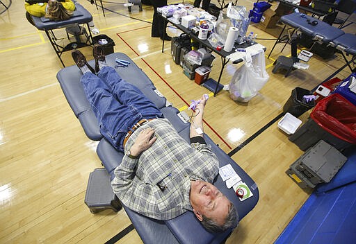 Gary Smith, of Uniondale, donates blood during a blood drive at the Carbondale YMCA in Carbondale, Pa., on Thursday, March 26, 2020. The American Red Cross reports a critical need of blood due the coronavirus. (Jake Danna Stevens/The Times-Tribune via AP)