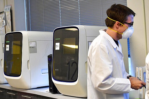 Molecular technologists work next to QuantStudio 12K Flex Real Time PCR machines that test for COVID-19 at MHS Labs, Friday, March 27, 2020, in Monroeville, Pa. (Matt Freed/Pittsburgh Post-Gazette via AP)