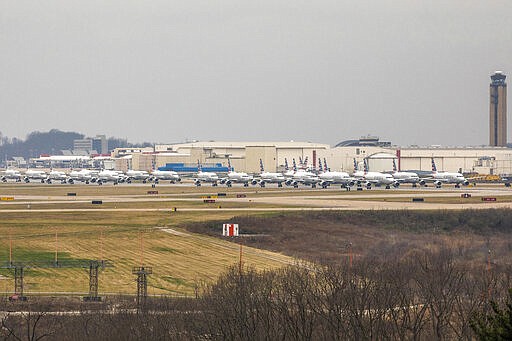 Dozens of parked American Airlines planes are parked at the Pittsburgh International Airport, Friday, March 27, 2020, in Moon, Pa. The airport has become a parking destination for the airline during the COVID-19 shutdown. (Andrew Rush/Pittsburgh Post-Gazette via AP)