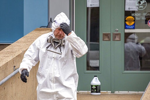 Mike Zajicek, of sanitization company Jan-Pro of Pittsburgh, prepares to clean the Magee Recreation Center, Friday, March 27, 2020, in the Greenfield neighborhood of Pittsburgh. The center was cleaned after possible exposure of a confirmed case of COVID-19. (Andrew Rush/Pittsburgh Post-Gazette via AP)