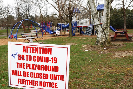 A sign with corrected spelling, tells visitors the playground at the Community Park is closed until further notice due to COVID-19, Friday, March 27, 2020, in Zelienople, Pa. The new coronavirus causes mild or moderate symptoms for most people, but for some, especially older adults and people with existing health problems,  it can cause more severe illness or death. (AP Photo/Keith Srakocic)