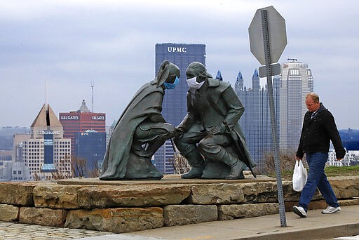 A man passes by the &quot;Point of View&quot; sculpture depicting George Washington and Seneca leader Guyasuta on Mount Washington, overlooking downtown Pittsburgh, Friday, March 27, 2020. (AP Photo/Gene J. Puskar)