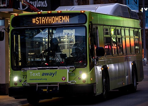 In this Monday, March 23, 2020, photo, Metro Transit busses travel with the hashtag #STAYHOMEMN during the coronavirus outbreak on Nicollet Mall in downtown Minneapolis. (Carlos Gonzalez/Star Tribune via AP)