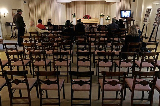 FILE - This March 18, 2020 file photo shows a funeral that was affected by new rules put in place due to the coronavirus outbreak in Milwaukee. Wisconsin Gov. Tony Evers restricted gatherings to less than 10 people the day before. As the COVID-19 death toll mounts, faith leaders are grappling with a heart-wrenching question: How do you conduct a funeral in the midst of a global pandemic? (AP Photo/Carrie Antlfinger)