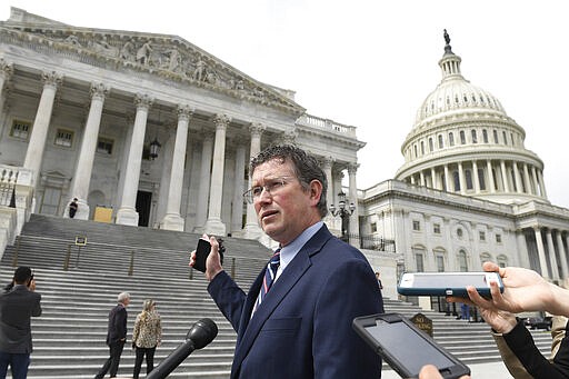 Rep. Thomas Massie, R-Ky., talks to reporters before leaving Capitol Hill in Washington, Friday, March 27, 2020, after attempting to slow action on a rescue package. Despite Massie's effort, the House, acting with exceptional resolve in an extraordinary time, rushed President Donald Trump a $2.2 trillion rescue package, tossing a life preserver to a U.S. economy and health care system left flailing by the coronavirus pandemic. (AP Photo/Susan Walsh)