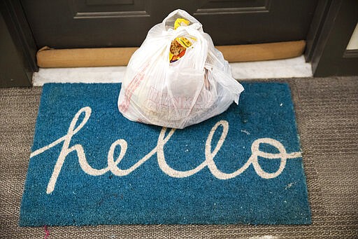 Groceries delivered by the nonprofit organization &quot;We Are Family DC,&quot; sit on a welcome mat that says &quot;hello,&quot; Saturday, March 21, 2020, in Washington. Seniors are being encouraged to stay in their homes due to the risk of the COVID-19 coronavirus. (AP Photo/Jacquelyn Martin)