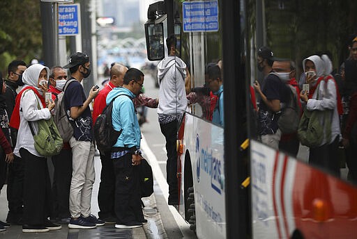 In this March 19, 2020, photo, people line up to get on a city bus at the main business district in Jakarta, Indonesia.&#160;The new coronavirus causes mild or moderate symptoms for most people, but for some, especially older adults and people with existing health problems, it can cause more severe illness or death. (AP Photo/Dita Alangkara)