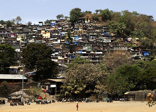 In this March 20, 2020, photo, a man walks near a slum in Mumbai, India. As the virus spreads, the World Health Organization has pointed out that the future of the pandemic will be determined by what happens in some of the world&#146;s poorest and most densely populated countries. From Mumbai to Rio de Janeiro to Johannesburg the question is: What do you do if there is no space to socially distance yourself from others in some of world&#146;s most unequal regions? (AP Photo/Rajanish Kakade)