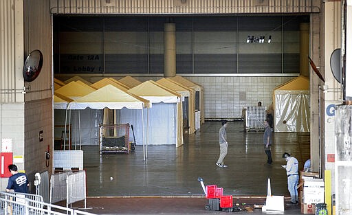 Workers prepare the Ernest N. Morial Convention Center Hall J on Friday, March 27, 2020, in New Orleans after Louisiana state health officials said they are planning to put more than 1,100 beds in the makeshift hospital for patients with the coronavirus. (David Grunfeld/The Advocate via AP)