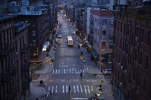 Bicyclists and a pedestrian pass through a quiet Manhattan street, Thursday, March 26, 2020, during the coronavirus pandemic in New York. Because of Gov. Andrew Cuomo's &quot;stay-at-home&quot; orders for all but essential workers, the streets are quieter than normal. (AP Photo/Mark Lennihan)