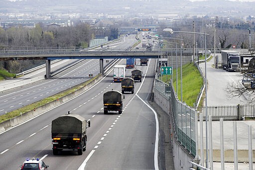 FILE - In this March 26, 2020 file photo, military trucks carrying coffins of deceased people are escorted on the highway next to Ponte Oglio, near Bergamo, one of the areas worst hit by the coronavirus infection, on their way from Bergamo cemetery to a crematory in some other location as the local crematory exceeded its maximum capacity. Italy is seeing a slight stabilizing in its confirmed coronavirus infections two weeks into the world&#146;s most extreme nationwide shutdown, but the virus is taking its silent spread south after having ravaged the health care system in the north. The new coronavirus causes mild or moderate symptoms for most people, but for some, especially older adults and people with existing health problems, it can cause more severe illness or death. (AP Photo/Luca Bruno, file)