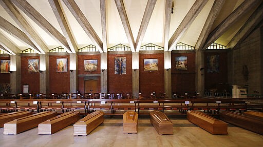 FILE - In this March 26, 2020 file photo, coffins are lined up on the floor in the San Giuseppe church in Seriate, one of the areas worst hit by coronavirus, near Bergamo, Italy, waiting to be taken to a crematory. Italy is seeing a slight stabilizing in its confirmed coronavirus infections two weeks into the world&#146;s most extreme nationwide shutdown, but the virus is taking its silent spread south after having ravaged the health care system in the north. The new coronavirus causes mild or moderate symptoms for most people, but for some, especially older adults and people with existing health problems, it can cause more severe illness or death. (AP Photo/Antonio Calanni, file)