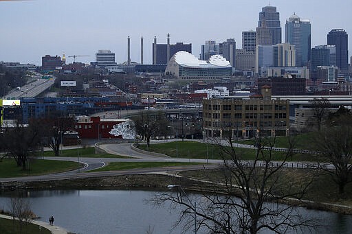 People, lower left, fish in a park, Thursday, March 26, 2020, in Kansas City, Mo. The city and surrounding counties are under a mandatory stay-at-home order to help stem the spread of the new coronavirus. (AP Photo/Charlie Riedel)