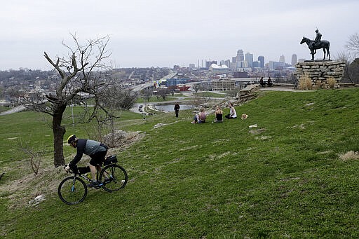 People get out for fresh air at a park, Thursday, March 26, 2020, in Kansas City, Mo. The city and surrounding counties are under a mandatory stay-at-home order to help stem the spread of the new coronavirus. (AP Photo/Charlie Riedel)