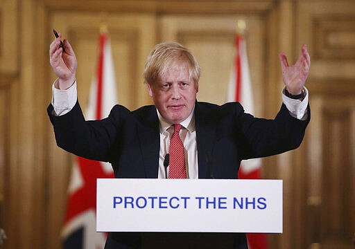 FILE - In this Sunday March 22, 2020 file photo British Prime Minister Boris Johnson gestures during his daily COVID 19 coronavirus press briefing to announce new measures to limit the spread of the virus, at Downing Street in London.  British Prime Minister Boris Johnson has tested positive for the new coronavirus. Johnson's office said Friday March 27, 2020 that he was tested after showing mild symptoms, Downing St. says Johnson is self-isolating and continuing to lead the country's response to COVID-19.  (Ian Vogler / Pool via AP, File)