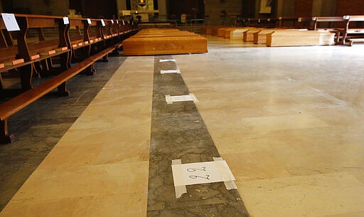 FILE - In this March 26, 2020 file photo, numbers on the floor inside the San Giuseppe church in Seriate, one of the areas worst hit by coronavirus, near Bergamo, Italy, mark spaces where coffins are to be placed before being taken to a crematory. Italy is seeing a slight stabilizing in its confirmed coronavirus infections two weeks into the world&#146;s most extreme nationwide shutdown, but the virus is taking its silent spread south after having ravaged the health care system in the north. The new coronavirus causes mild or moderate symptoms for most people, but for some, especially older adults and people with existing health problems, it can cause more severe illness or death. (AP Photo/Antonio Calanni, file)