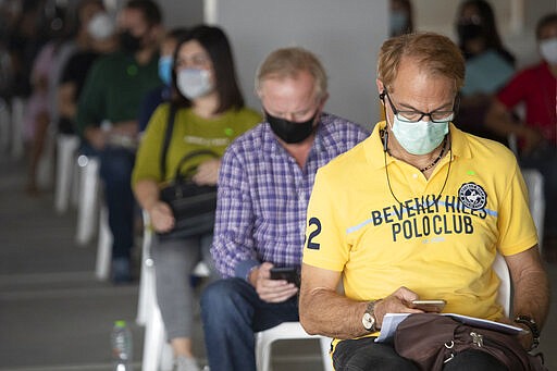 Tourists keep social distancing as they wait to extend their visa at Immigration Bureau in Bangkok, Thailand, Friday, March 27, 2020. Tourists across Asia are finding their dream vacations have turned into travel nightmares as airlines cancel flights and countries close their borders in the fight against the coronavirus pandemic. (AP Photo/Sakchai Lalit)