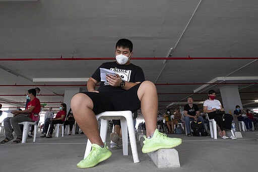 Tourists practice social distancing as they wait to extend their visa at Immigration Bureau in Bangkok, Thailand, Friday, March 27, 2020. Tourists across Asia are finding their dream vacations have turned into travel nightmares as airlines cancel flights and countries close their borders in the fight against the coronavirus pandemic. (AP Photo/Sakchai Lalit)