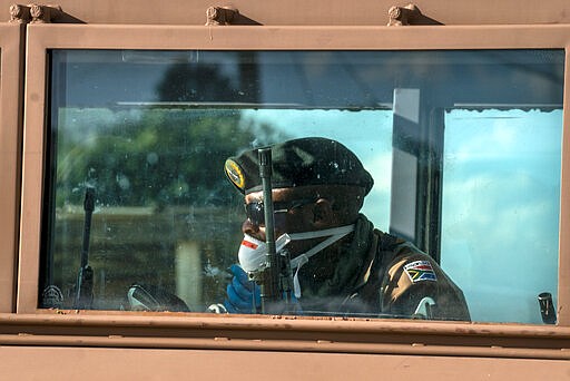 South African National Defense Forces patrol the densely populated Alexandra township east of Johannesburg Friday, March 27, 2020. South Africa went into a nationwide lockdown for 21 days in an effort to mitigate the spread to the coronavirus, but in Alexandra, many people were gathering in the streets disregarding the lockdown. The new coronavirus causes mild or moderate symptoms for most people, but for some, especially older adults and people with existing health problems, it can cause more severe illness or death.(AP Photo/Jerome Delay)