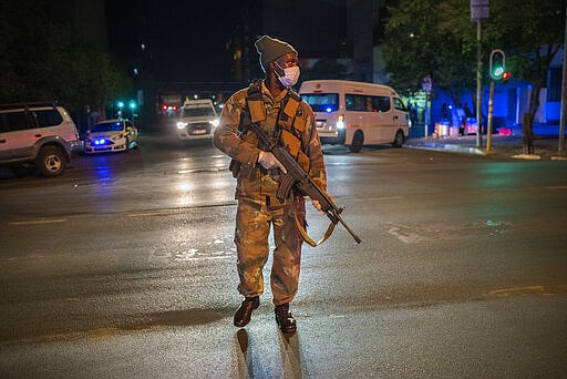 A South African soldier enforces the lockdown downtown Johannesburg, South Africa, Friday, March 27, 2020. Police and army started patrolling moments after South Africa went into a nationwide lockdown for three weeks in an effort to mitigate the spread to the coronavirus. The new coronavirus causes mild or moderate symptoms for most people, but for some, especially older adults and people with existing health problems, it can cause more severe illness or death.(AP Photo/Jerome Delay)