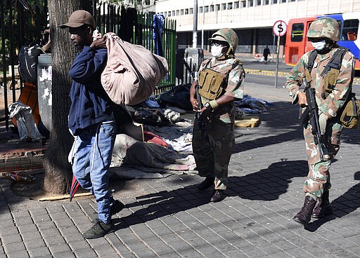 Soldiers apprehend a homeless man in a roundup of homeless people in downtown Johannesburg Friday, March 27, 2020, after South Africa went into a nationwide lockdown for 21 days in an effort to mitigate the spread to the coronavirus. The new coronavirus causes mild or moderate symptoms for most people, but for some, especially older adults and people with existing health problems, it can cause more severe illness or death(AP Photo)