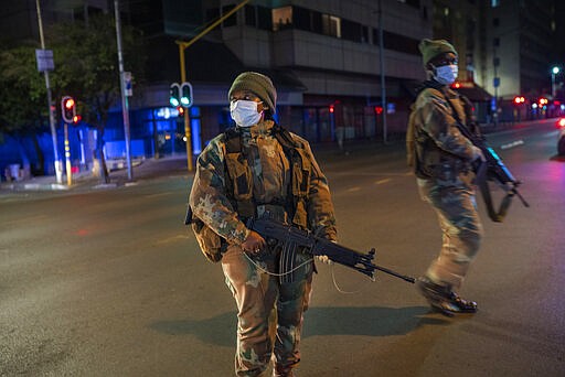 South African Defense Forces patrol downtown Johannesburg, South Africa, Friday, March 27, 2020. Police and army started patrolling moments after South Africa went into a nationwide lockdown for 21 days in an effort to mitigate the spread to the coronavirus. The new coronavirus causes mild or moderate symptoms for most people, but for some, especially older adults and people with existing health problems, it can cause more severe illness or death.(AP Photo/Jerome Delay)