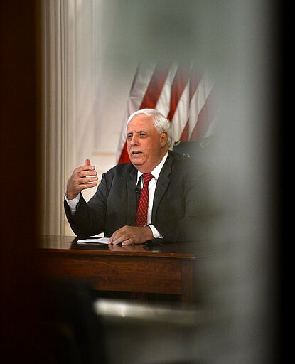 West Virginia governor Jim Justice Monday, March, 23, 2020, issued a stay at home order, effective 8 p.m. Tuesday from his office in the WV State Capitol in Charleston, W. Va. Orders all non-essential businesses closed. (Kenny Kemp/Charleston Gazette-Mail via AP)