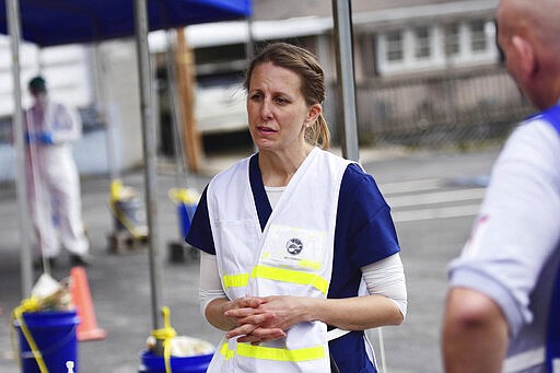 Dr. Anita Stewart speaks with clinical care providers during drive-thru testing by the Fayette County Health Department in Oak Hill, W.V. on Thursday, March 19, 2020. (Chris Jackson/The Register-Herald via AP)